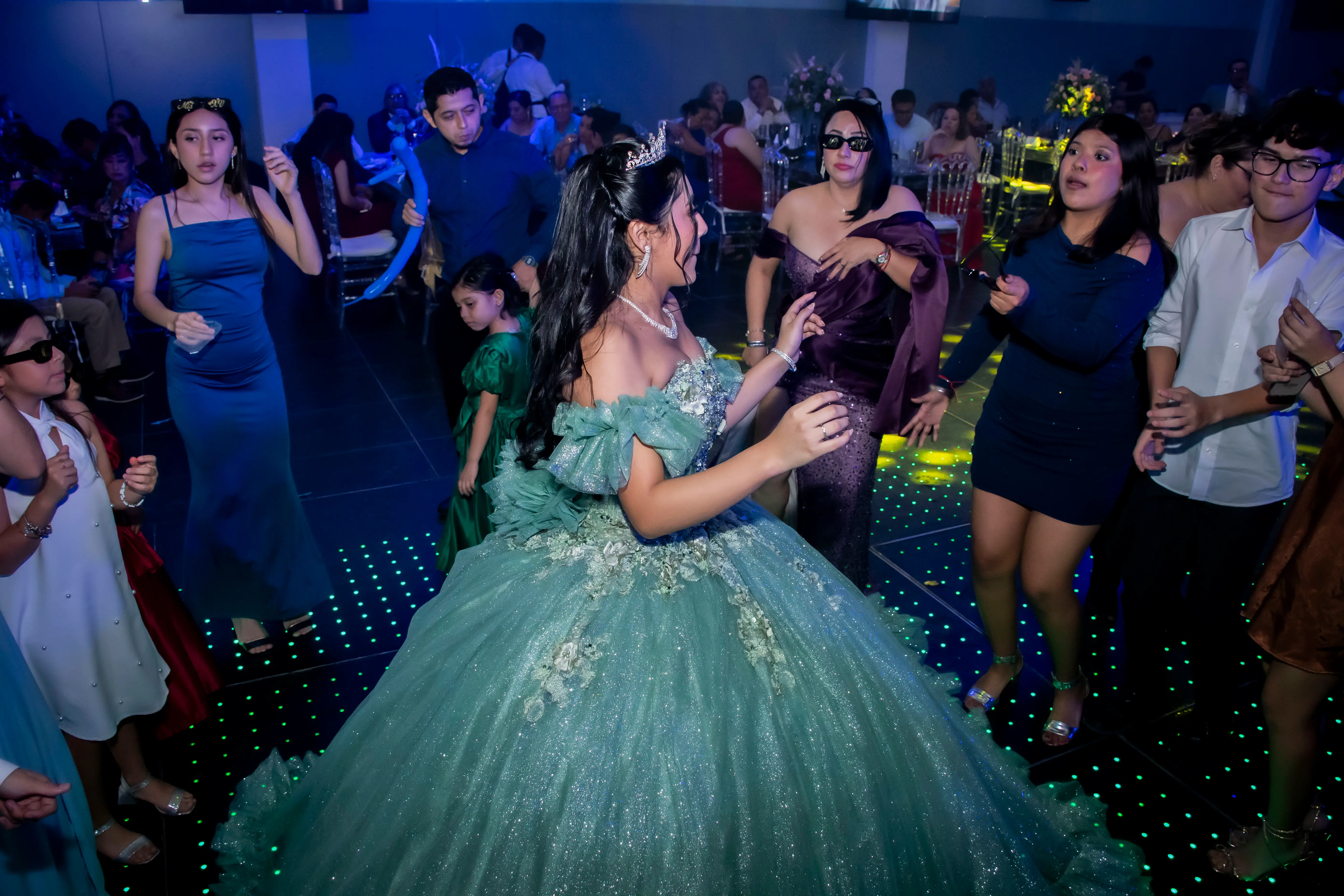 Quinceañera en pista de baile iluminada
